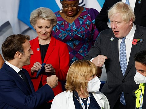 French President Emmanuel Macron (left) gestures as he speaks to British Prime Minister Boris Johnson during the G20 Summit at the convention centre "La Nuvola" in the EUR district of Rome on October 30, 2021. 