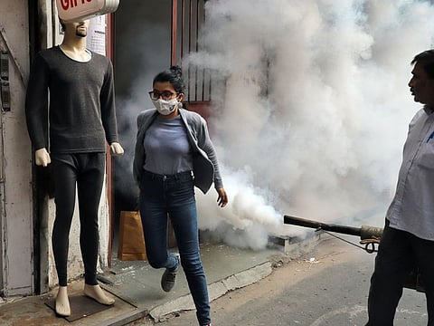 A worker fumigates inside a shop as part of measures to control the dengue outbreak, at Gole market, in New Delhi, last week.