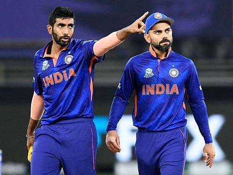 India's Jasprit Bumrah (left) gestures as captain Virat Kohli watches during the ICC Men’s Twenty20 World Cup cricket match against New Zealand at the Dubai International Cricket Stadium on October 31, 2021. 