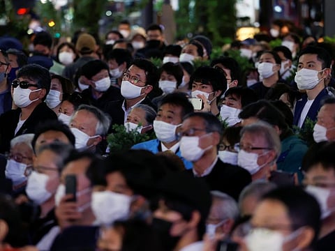 Japanese listen to a speech by Prime Minister Fumio Kishida, who is also the President of the ruling Liberal Democratic Party, on the last day of campaigning for the October 31 lower house election, amid COVID-19 pandemic, in Tokyo, on October 30, 2021.