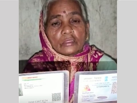 Buchun Devi showing her official documents, including Aadhar card. 