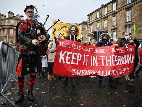 A piper plays the bagpipes as people participate in a protest rally during a global day of action on climate change in Glasgow on November 6, 2021, during the COP26 UN Climate Change Conference. - Glasgow was on Saturday bracing for a second day of protests against what campaigners say is a lack of urgency to address global warming after Greta Thunberg labelled the crunch UN climate summit there a "failure". From Paris to Sydney, Nairobi to Seoul, more than 200 events are planned worldwide to demand immediate action for communities already affected by climate change, particularly in the poorer countries in the South. 