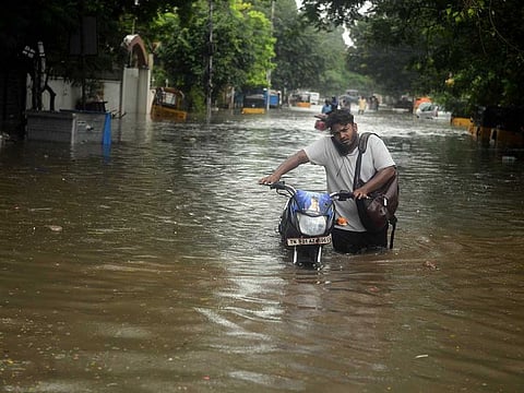A motorcyclist makes his way through a waterlogged road following heavy rainfall, in Chennai on Sunday, November 7, 2021. 