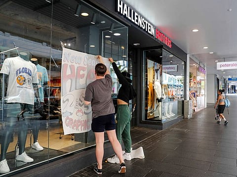 Staff prepare a store for reopening in central Auckland, New Zealand on November 8, 2021. 