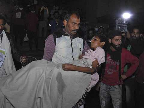 A man carries a child out from the Kamla Nehru Children’s Hospital after a fire in the newborn care unit of the hospital killed four infants, in Bhopal.