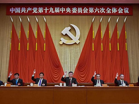 In this photo released by Xinhua News Agency, members of the Standing Committee of the Political Bureau of the Communist Party of China (CPC) Central Committee including Chinese President Xi Jinping, centre, and Premier Li Keqiang, third right, raise hands as they attend the sixth plenary session of the 19th Central Committee of the Communist Party of China (CPC) in Beijing, Thursday, Nov. 11, 2021. 