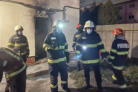 In this image released by Romania's Emergency Situations Inspectorate, firefighters stand at the site of a hospital fire in Ploiesti, Romania, Thursday, Nov. 11, 2021.