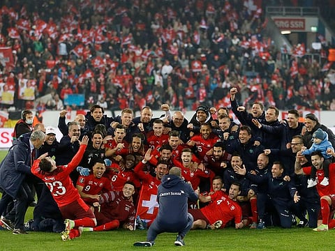 Switzerland players pose for a picture to celebrate winning the match and qualifying for the Qatar 2022 World Cup.