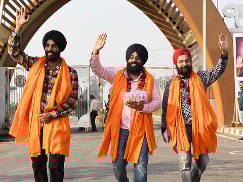 Sikh pilgrims gesture as they return from the Gurdwara Darbar Kartarpur Sahib in Pakistan after paying their respect on the occasion of Sikhism founder Guru Nanak's birth anniversary at the Kartarpur Sahib corridor, some 25km from Batala on November 17, 2021. 