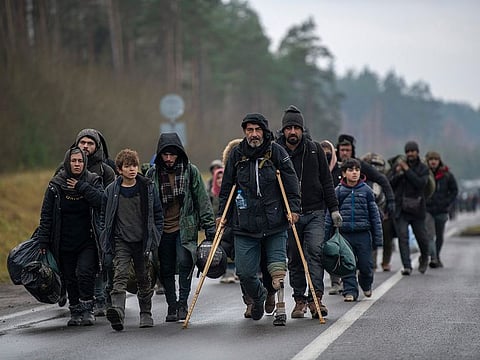 Migrants walking from the Polish border to a warehouse shelter  in Bruzgi, Belarus.  