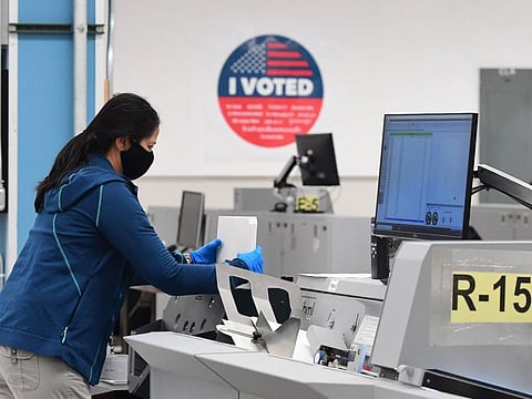 Ballots are counted at the tallying centre in Downey, California, after the close of voting in California's gubernatorial recall election in a file picture. The US Justice Department announced indictments of two Iranians who allegedly took part in an online "disinformation and threat" campaign to influence American voters in the 2020 presidential election. 