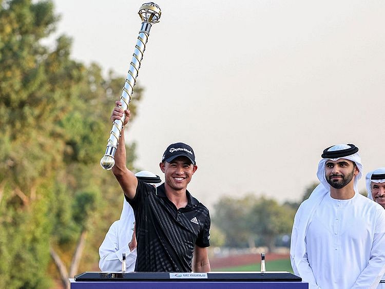 Collin Morikawa of the US holds the winners' baton during the awards ceremony of the Dubai DP World Tour Championship at Jumeirah Golf Estates in Dubai