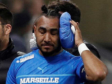 Olympique de Marseille's Dimitri Payet walks off the pitch injured after being hit by a water bottle thrown by a fan leading to the game being interrupted.