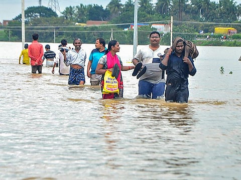  Residents wade through a flood-hit area of Nellore district in Andhra Pradesh.