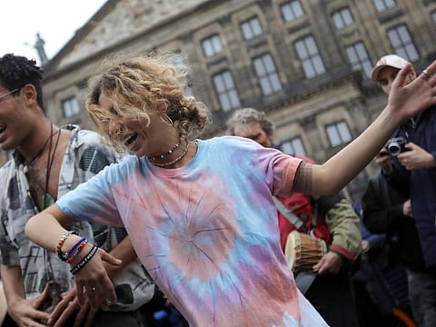 Protesters dance during a demonstration against COVID-19 measures in Amsterdam, on November 20, 2021. 