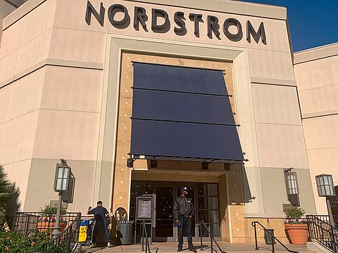 A security guard stands outside the Nordstrom store at The Grove retail and entertainment complex in Los Angeles, Tuesday, Nov. 23, 2021.