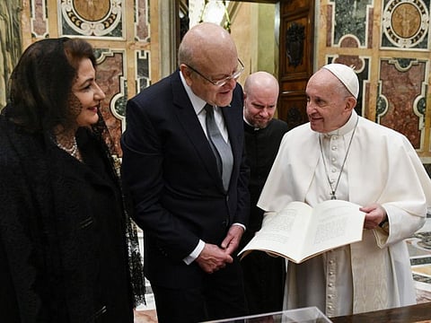 This handout photo taken and released on November 25, 2021 by the Vatican press office shows Pope Francis during a private audience with Lebanon's Prime Minister Najib Mikati at the Vatican. 