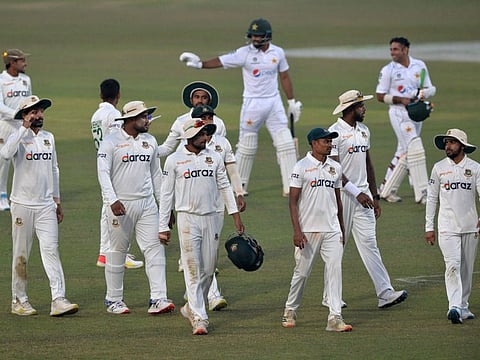 Bangladesh's and Pakistan's players walk back to the pavilion at the end of the second day play of the first Test cricket match between Bangladesh and Pakistan at the Zahur Ahmed Chowdhury Stadium in Chittagong.