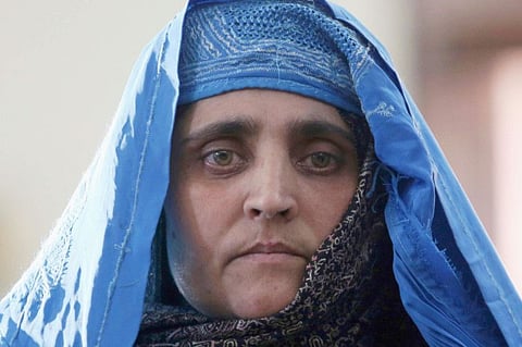 National Geographic's famed green-eyed 'Afghan Girl' Sharbat Gulla poses for a photo during a meeting with Afghan President Ashraf Ghani, at the Presidential palace in Kabul, Afghanistan, Nov. 9, 2016. Sharbat Gulla has been evacuated to Italy and the government will now help to get her integrated into life in the country.