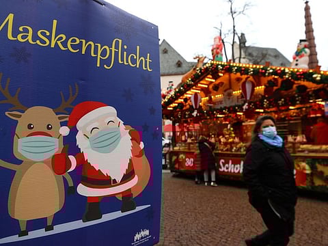 A sign showing mask requirement for visitors is seen at the Christmas market as the spread of COVID-19 pandemic continues in Frankfurt, on November 29, 2021. 