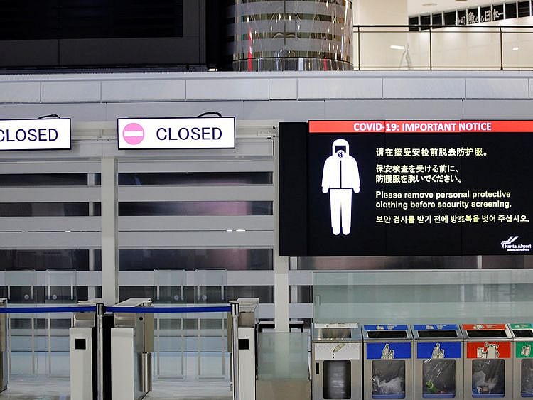  A notice about COVID-19 safety measures is pictured next to closed doors at a departure hall of Narita international airport on the first day of closed borders to prevent the spread of Omicron variant in Narita, east of Tokyo, on November 30, 2021. 