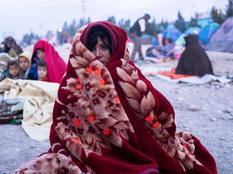 An Afghan woman and her family camp outside the Directorate of Disaster that they camp, in Herat, Afghanistan, on November 29, 2021. 