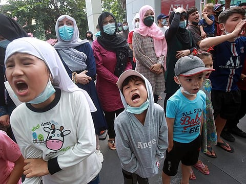 Afghan refugees shout slogans during a rally outside the building that houses the local UNHCR representative office in Medan, North Sumatra, Indonesia, on Tuesday, Nov. 30, 2021. 