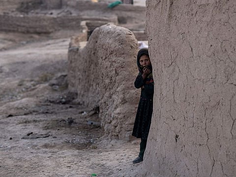 An Afghan girl looks out of her house in Kamar Kalagh village near Herat on November 27, 2021. The United Nations is predicting that a record 274 million people – who together would amount to the world’s fourth most-populous country – will require emergency humanitarian aid next year in countries including Afghanistan, Ethiopia, Myanmar, Syria and Yemen as they face a raft of challenges such as war, insecurity, hunger, climate change and the pandemic. 