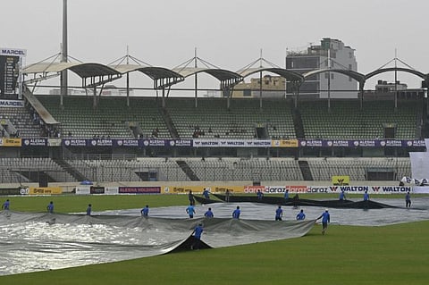 Groundstaff cover the field as it starts to rain on the second day of the second Test cricket match between Bangladesh and Pakistan at the Sher-e-Bangla National Cricket Stadium in Dhaka.