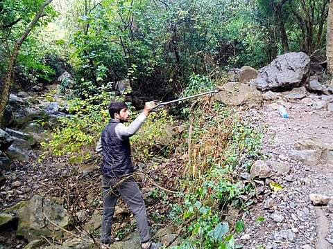 A nature lover collects trash from Pakistan's Margalla Hills.