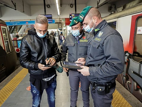 Guardia di Finanza officers check the coronavirus disease (COVID-19) health pass, known as a Green Pass, of a man at a train station the day the government restricts access of unvaccinated, in Naples, Italy December 6, 2021.