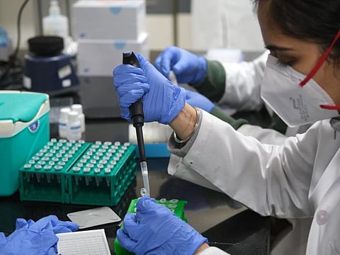 A technician uses a pipette while preparing test samples inside a COVID-19 Genome Sequencing Laboratory at the Institute of Liver and Biliary Sciences in New Delhi.
