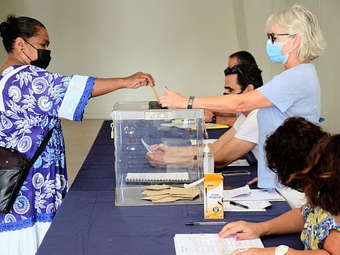 A woman casts her ballot for the referendum on independence at a polling station of the City Hall in Noumea, on the French South Pacific territory of New Caledonia on December 12, 2021.
