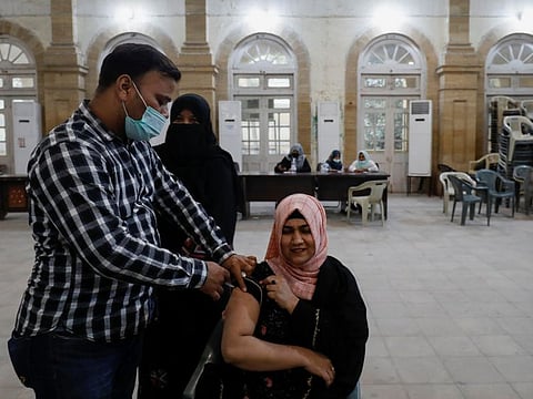 A woman receives a dose of COVID-19 vaccine in Karachi on December 6, 2021. 