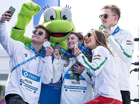 Selfie-time: Members of the Hungary team pose with the mascot of FINA World Swimming outside Etihad Arena in Abu Dhabi.