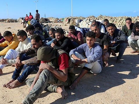 Migrants rescued by Tunisia's national guard during an attempted crossing of the Mediterranean by boat, rest on the beach at the port of Al Ketef in Ben Guerdane in southern Tunisia near the border with Libya, on December 15, 2021.  