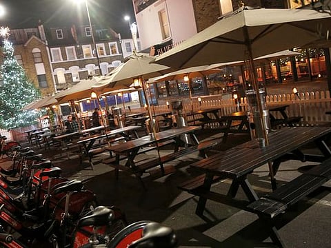 Empty tables at a bar usually crowded with customers in London, amid record-breaking cases in Britain.