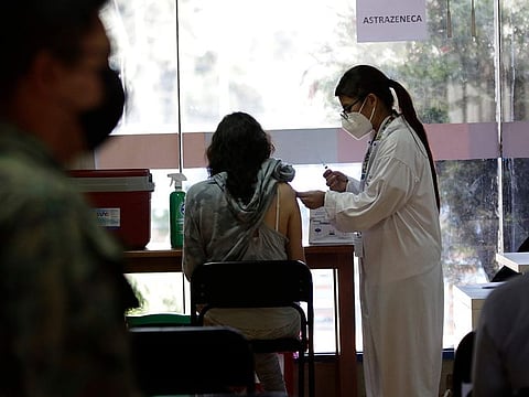 A woman gets her shot of the COVID-19 vaccine, in Quito, Ecuador, Thursday, Dec. 23, 2021. 