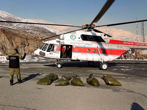 Bags containing bodies of mountaineers who died after avalanches in a mountainous area north of Tehran are placed on the ground carried by a rescue helicopter.