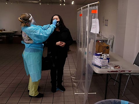 A nurse collects a nasal swab sample from a woman who declined to give her name at a COVID-19 testing site in Los Angeles, on December 27, 2020. 