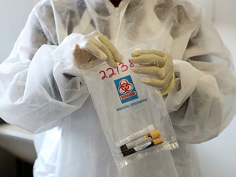 A health worker holds a COVID-19 sample collection kit of a vaccine trials' volunteer, after they were tested for the coronavirus disease and take part in the country's human clinical trial for potential vaccines at the Wits RHI Shandukani Research Centre in Johannesburg, South Africa, August 27, 2020.