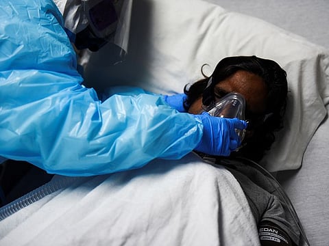 A healthcare worker places a BiPAP machine on a patient infected with the COVID-19 at United Memorial Medical Center in Houston, Texas, on December 28, 2020.  