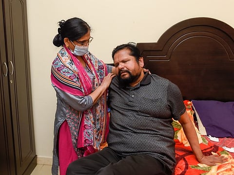 Mohandhas Aiyapillai being helped by his wife Kamala