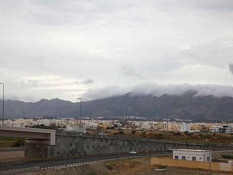 Clouds cover mountain tops n Oman's Al Amirat area, on January 1, 2022. Six people died amid heavy rainfall across the Sultanate