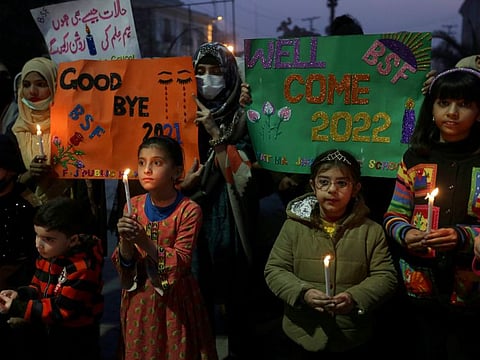 Students hold candles while participating in a demonstration to say goodbye to the year 2021 and welcome 2022, in Lahore. 