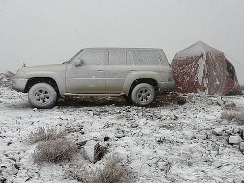 A man camps out in a tent next to his 4WD in Tabuk. The peak of Jabal Al Lawz was completely covered in white, as the Tabuk region witnessed heavy rain and snowfall since the early morning hours on Saturday.