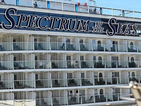 Passengers and crew are seen on the "Spectrum of the Seas" cruise ship in Hong Kong on January 5, 2022, after it was ordered to return to the city for coronavirus testing after nine people were found to be close contacts with a recent Omicron variant outbreak. 