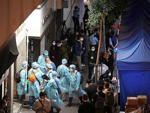 Workers wearing protective suits arrive to a building under lockdown for compulsory testing, following the coronavirus disease (COVID-19) outbreak in Hong Kong, China January 7, 2022. 