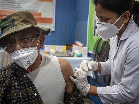 An elderly Indian man receives a third dose of vaccination for COVID-19 at a government hospital in Gauhati, India, Monday, Jan. 10, 2022. Healthcare and front-line workers along with people above age 60 with health problems lined up Monday at vaccination centres across India to receive a third vaccination as infections linked to the omicron variant surge.