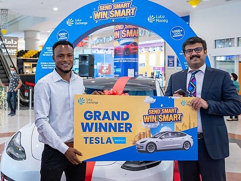 Shafeez Ahamed, DGM, LuLu International Exchange, handing over the grand prize of Tesla Model 3 to Abdul Gani, winner of LuLu Exchange's Send Smart Win Smart 2021 contest